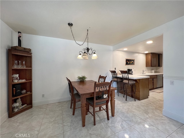 dining space with sink and a notable chandelier