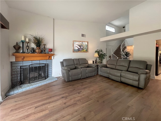 living room featuring high vaulted ceiling and wood-type flooring