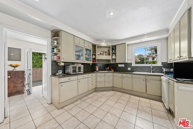 kitchen with light tile patterned floors, sink, cream cabinets, backsplash, and dishwasher