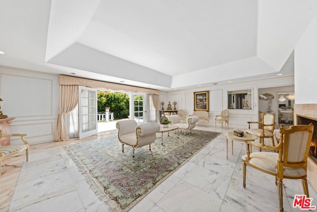 living room with french doors and a raised ceiling