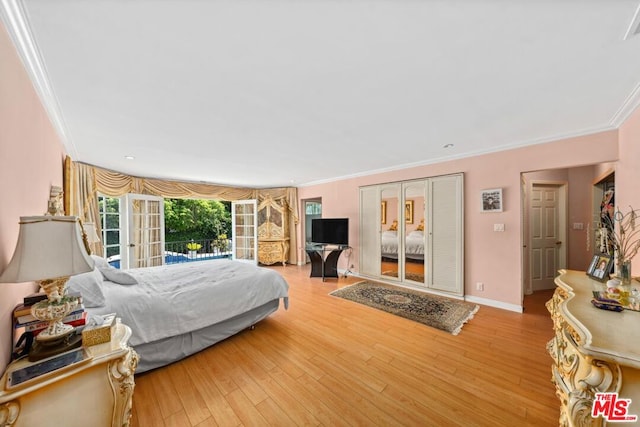 bedroom featuring light wood-type flooring and crown molding