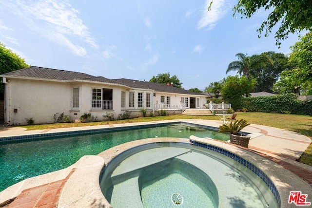 view of swimming pool featuring a yard and an in ground hot tub