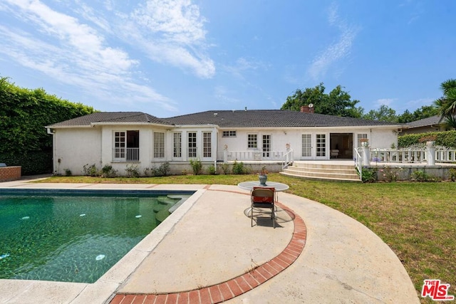 rear view of house with a patio and a yard