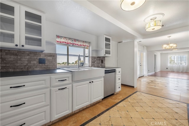 kitchen featuring dishwasher, decorative backsplash, and white cabinetry