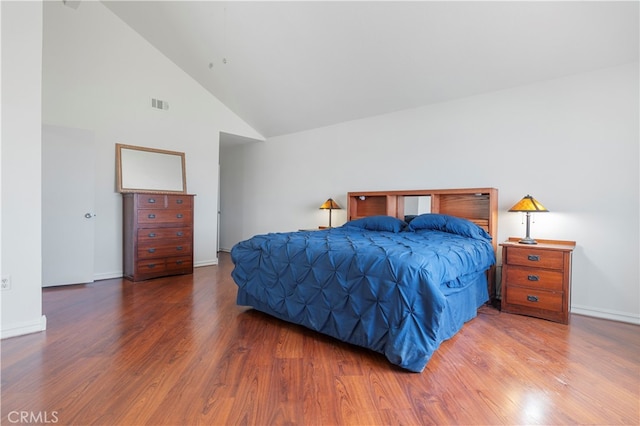 bedroom featuring hardwood / wood-style flooring and high vaulted ceiling