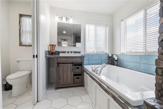 bathroom with vanity, toilet, a washtub, and tile patterned floors