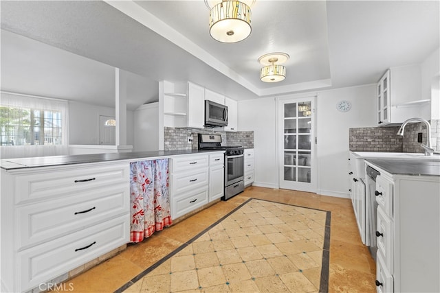 kitchen with decorative backsplash, white cabinets, appliances with stainless steel finishes, and stainless steel counters