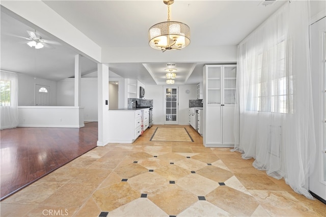 entrance foyer featuring ceiling fan with notable chandelier and light hardwood / wood-style floors