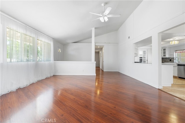 unfurnished living room with high vaulted ceiling, ceiling fan, hardwood / wood-style floors, and sink