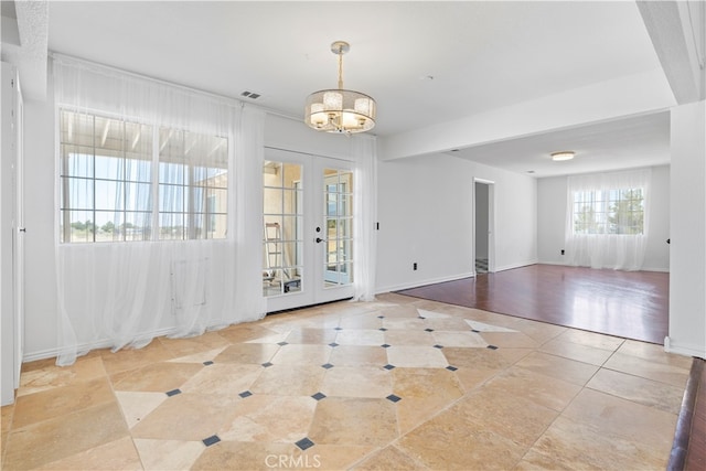 entryway with a chandelier, french doors, and light hardwood / wood-style flooring