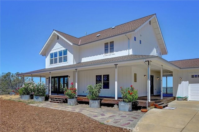 back of house featuring a porch and a garage