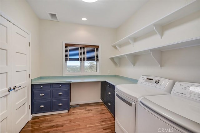 laundry area with cabinets, independent washer and dryer, and light wood-type flooring