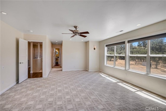 empty room featuring light colored carpet and ceiling fan