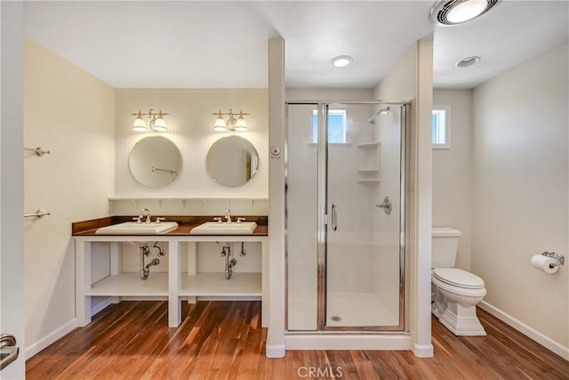 full bathroom featuring a stall shower, a sink, and wood finished floors