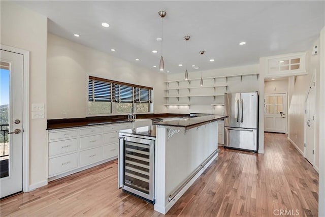 kitchen featuring pendant lighting, white cabinetry, wine cooler, stainless steel fridge, and plenty of natural light