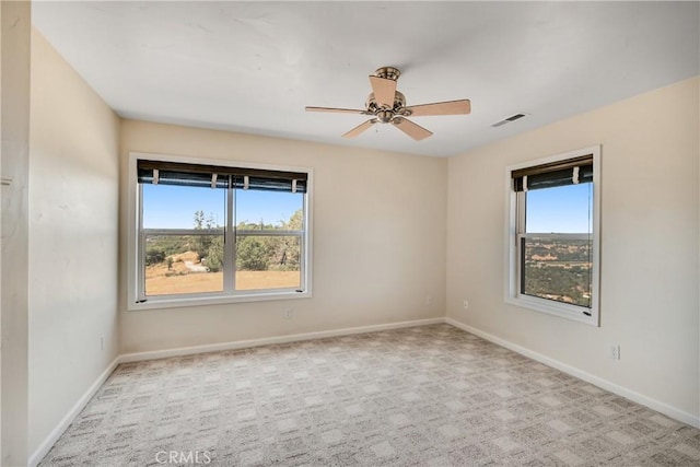 carpeted spare room featuring ceiling fan