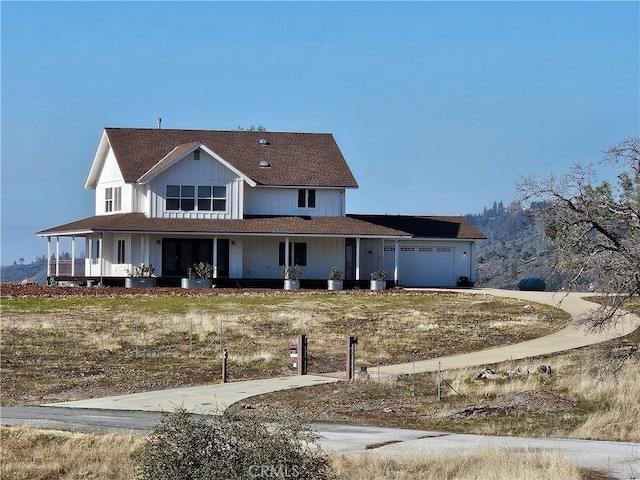 farmhouse inspired home featuring covered porch and a garage