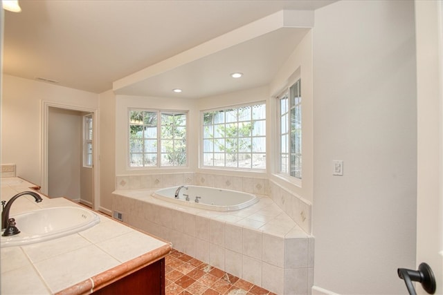 bathroom with a relaxing tiled tub and vanity