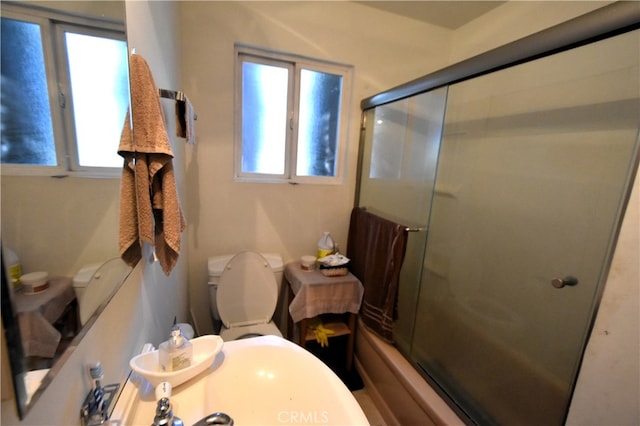 bathroom with shower / bath combination with glass door and toilet