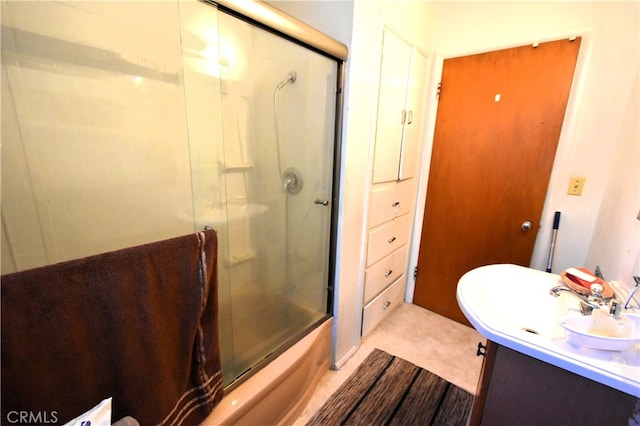 bathroom featuring combined bath / shower with glass door and vanity