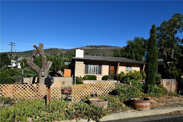 view of front of house with metal roof, fence, and a standing seam roof