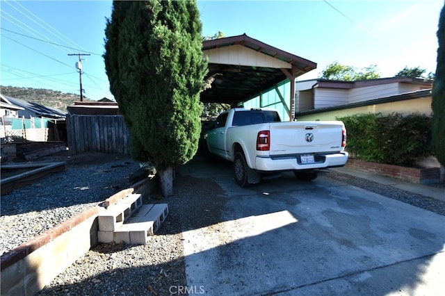 view of parking / parking lot with concrete driveway and a carport