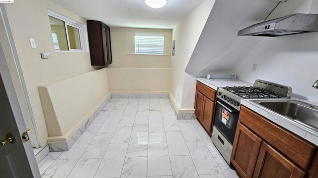 kitchen with stainless steel gas range oven, sink, and extractor fan