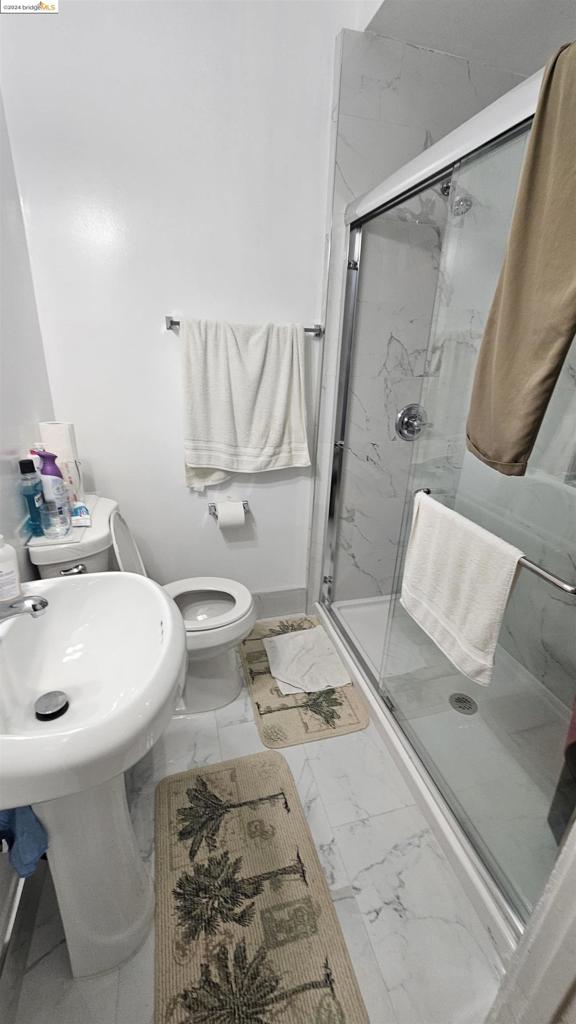 bathroom with walk in shower and toilet