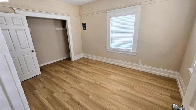 unfurnished bedroom with light hardwood / wood-style floors and a closet