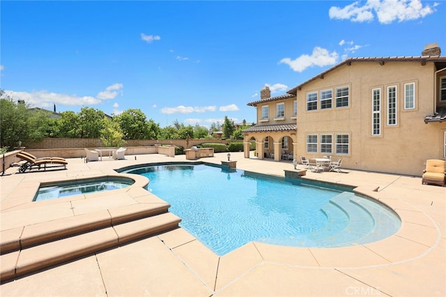 view of swimming pool with an in ground hot tub and a patio area