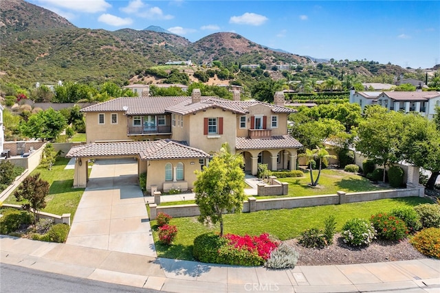 view of front facade with a mountain view, a front yard, and a garage