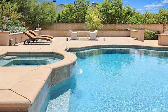 view of swimming pool with a patio, an in ground hot tub, and pool water feature