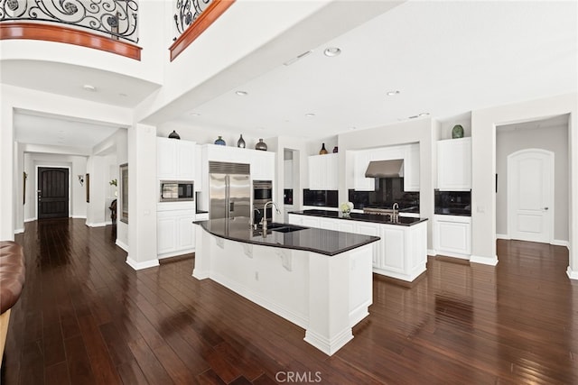 kitchen with a center island with sink, appliances with stainless steel finishes, sink, and white cabinetry