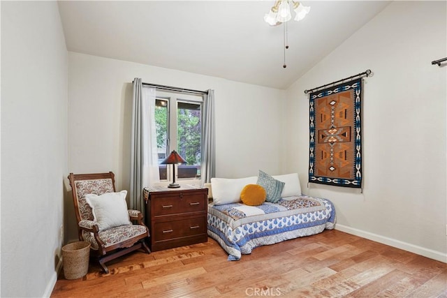 bedroom with light wood-type flooring and vaulted ceiling