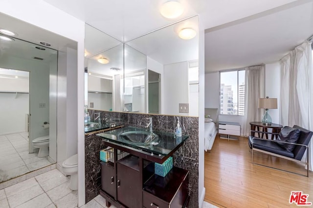 bathroom featuring vanity, toilet, backsplash, and wood-type flooring