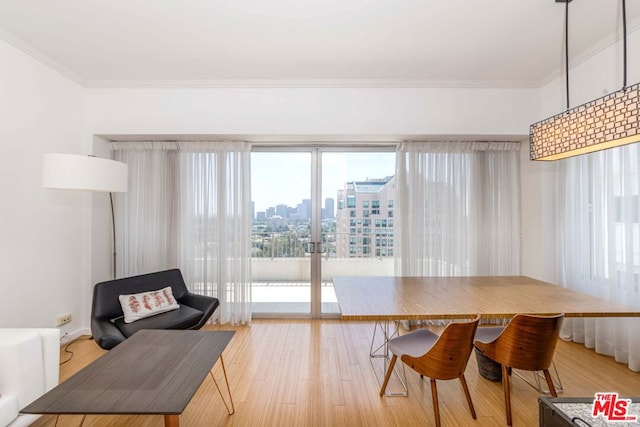 dining space with crown molding and light hardwood / wood-style flooring