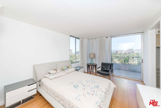 bedroom with wood-type flooring and access to outside