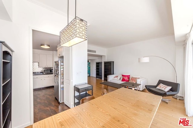 kitchen featuring appliances with stainless steel finishes, decorative light fixtures, white cabinetry, dark hardwood / wood-style flooring, and tasteful backsplash