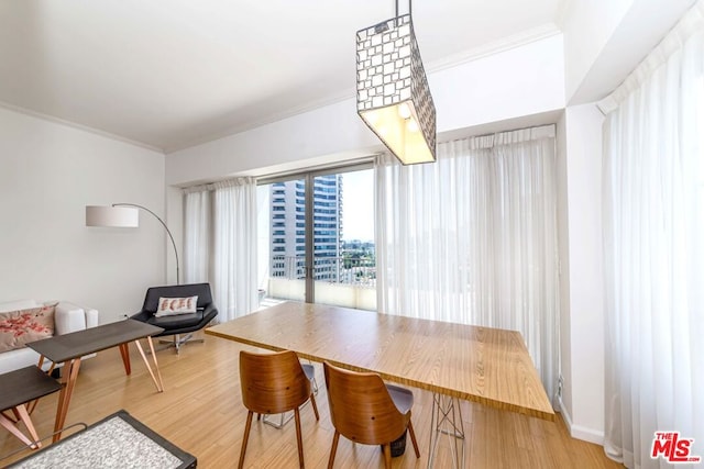 dining space with crown molding and light hardwood / wood-style floors