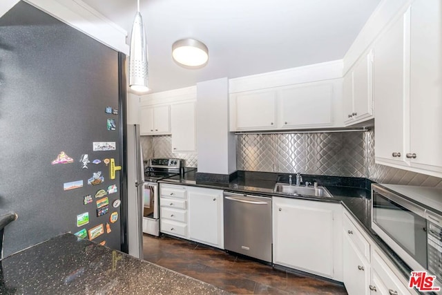 kitchen featuring appliances with stainless steel finishes, decorative light fixtures, white cabinetry, tasteful backsplash, and sink