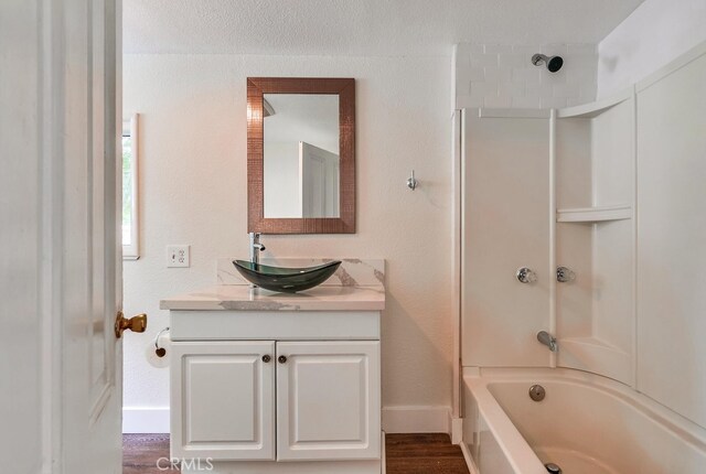 21457 Pecan St, Wildomar, CA 92595 - bathroom with vanity, bathtub / shower combination, a textured wall, and wood finished floors