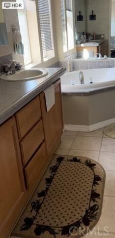 bathroom with a bath, tile patterned floors, and a sink