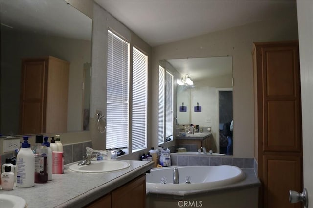 full bath featuring a bath, a sink, and double vanity