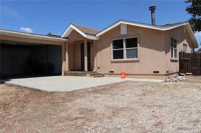 view of front of home featuring fence, stucco siding, crawl space, driveway, and a garage