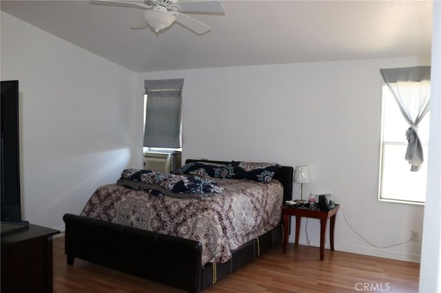 bedroom with baseboards, a ceiling fan, and wood finished floors