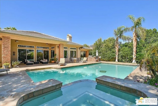 view of pool featuring an outdoor living space, an in ground hot tub, and a patio area