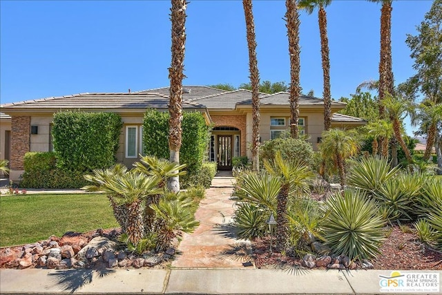 view of front facade with french doors and a front lawn