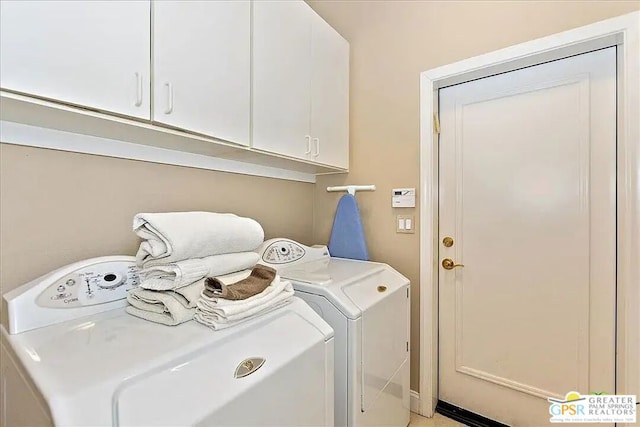 clothes washing area featuring washer and clothes dryer and cabinets