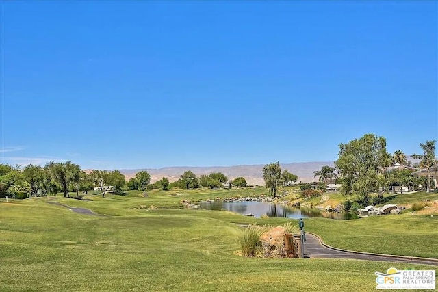 view of home's community featuring a water and mountain view and a lawn