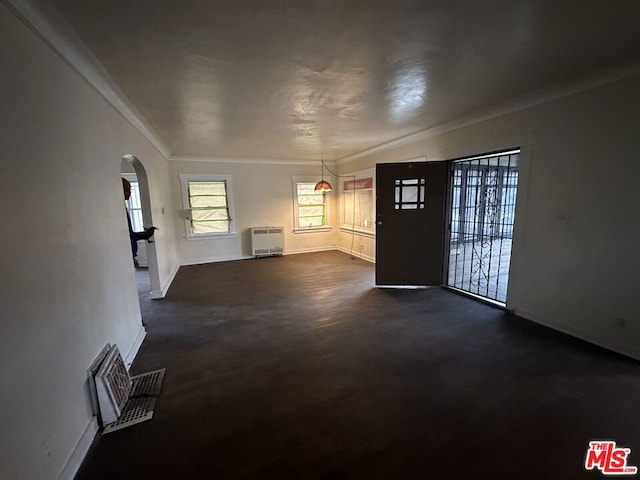 unfurnished living room with crown molding and heating unit